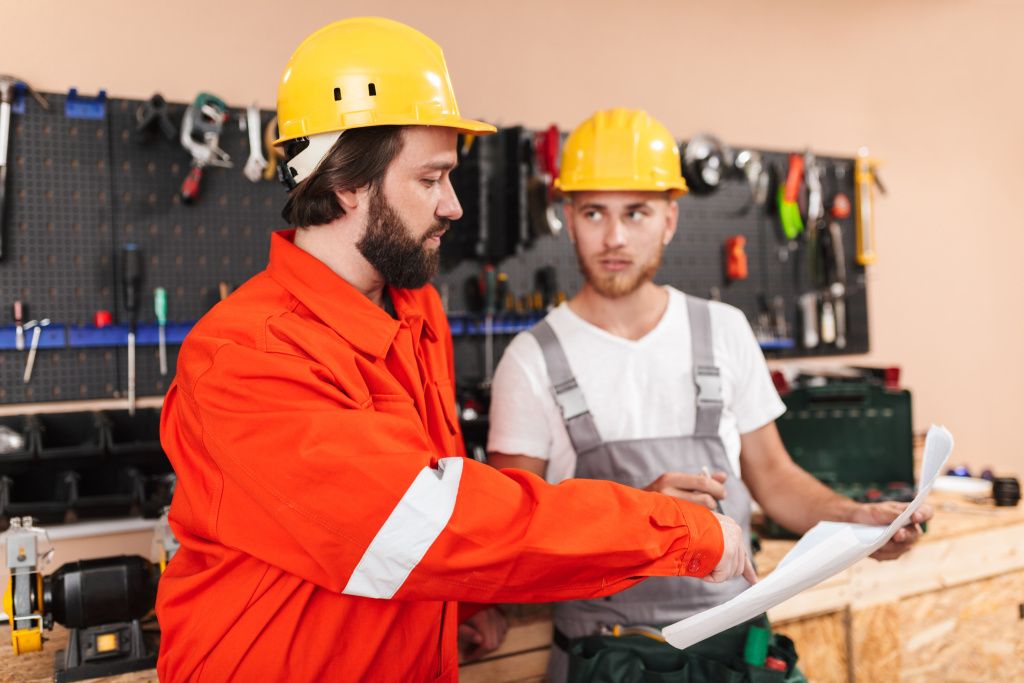 two-builders-work-clothes-yellow-hardhats-working-workshop-with-tools-background.jpg two-builders-work-clothes-yellow-hardhats-working-workshop-with-tools-background.jpg